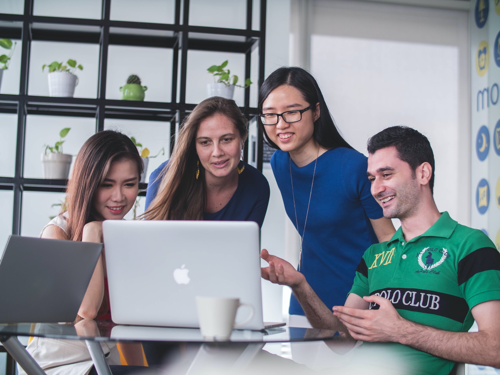 A design agency team collaborates on user interface design strategy around a laptop.