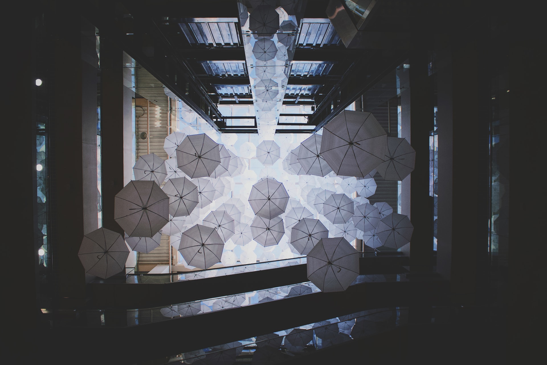 An abstract art installation of umbrellas hanging open.