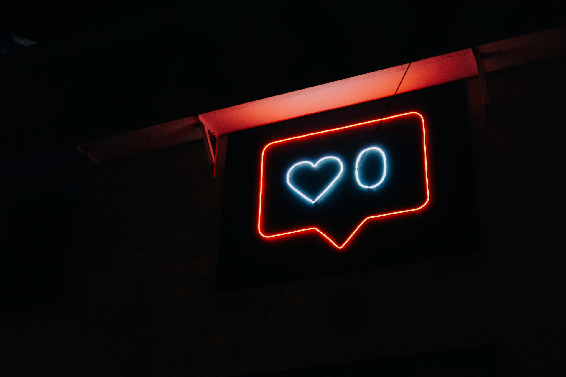 A neon sign showcasing a heart and the number 0 next to it. I