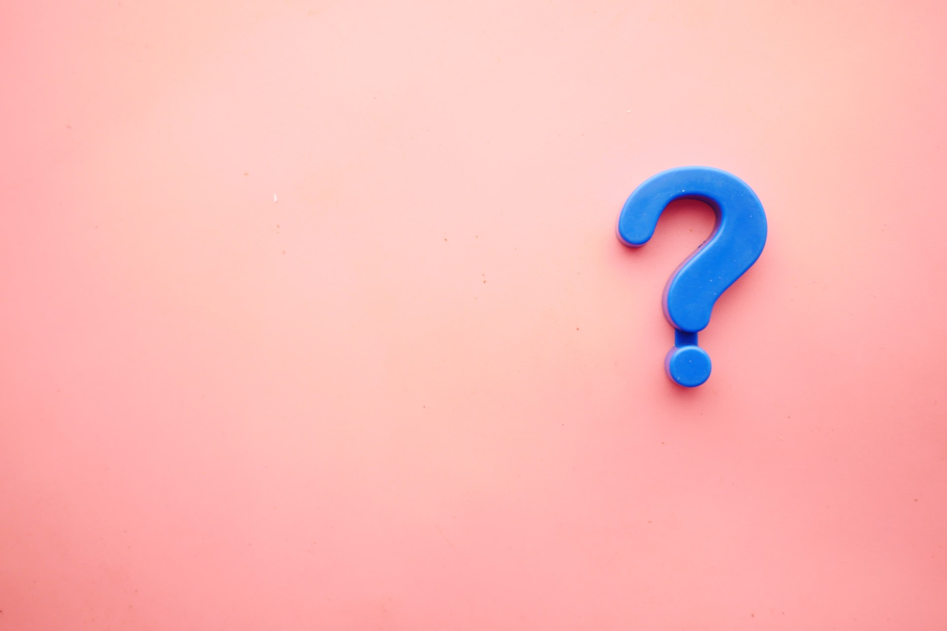 A pink backdrop with a blue magnet question mark.