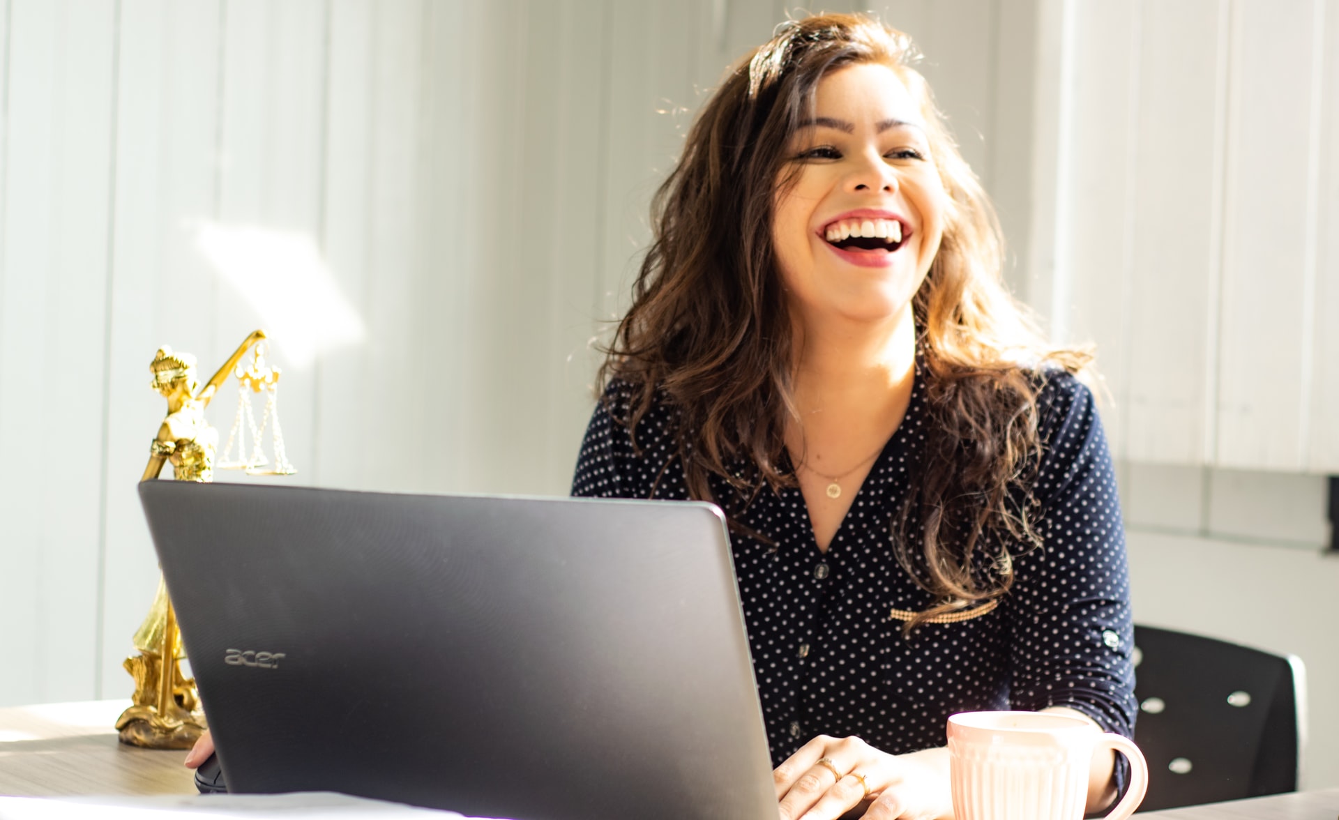 A person smiles at their desk.