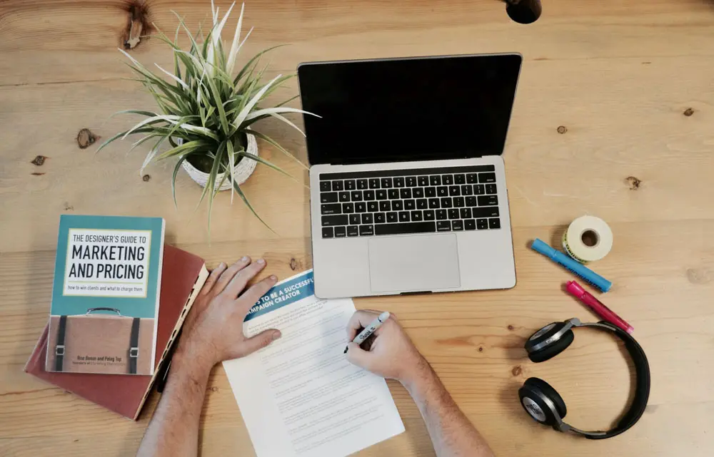 Top down view of a person ideating a design in front of a laptop.