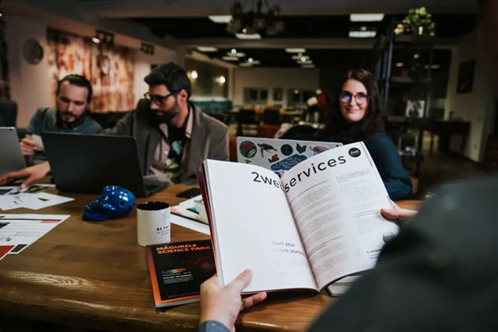 A design agency collaborating as one person reads a magazine on key principles.