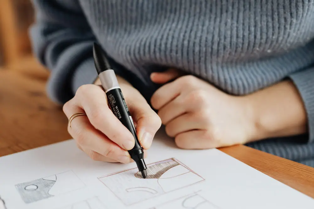 A designer creating logo design concepts and directions on paper.