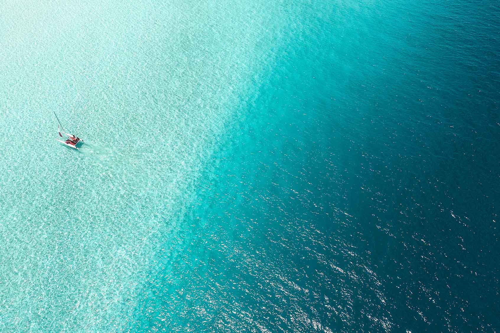 A top down view of the ocean and a boat.