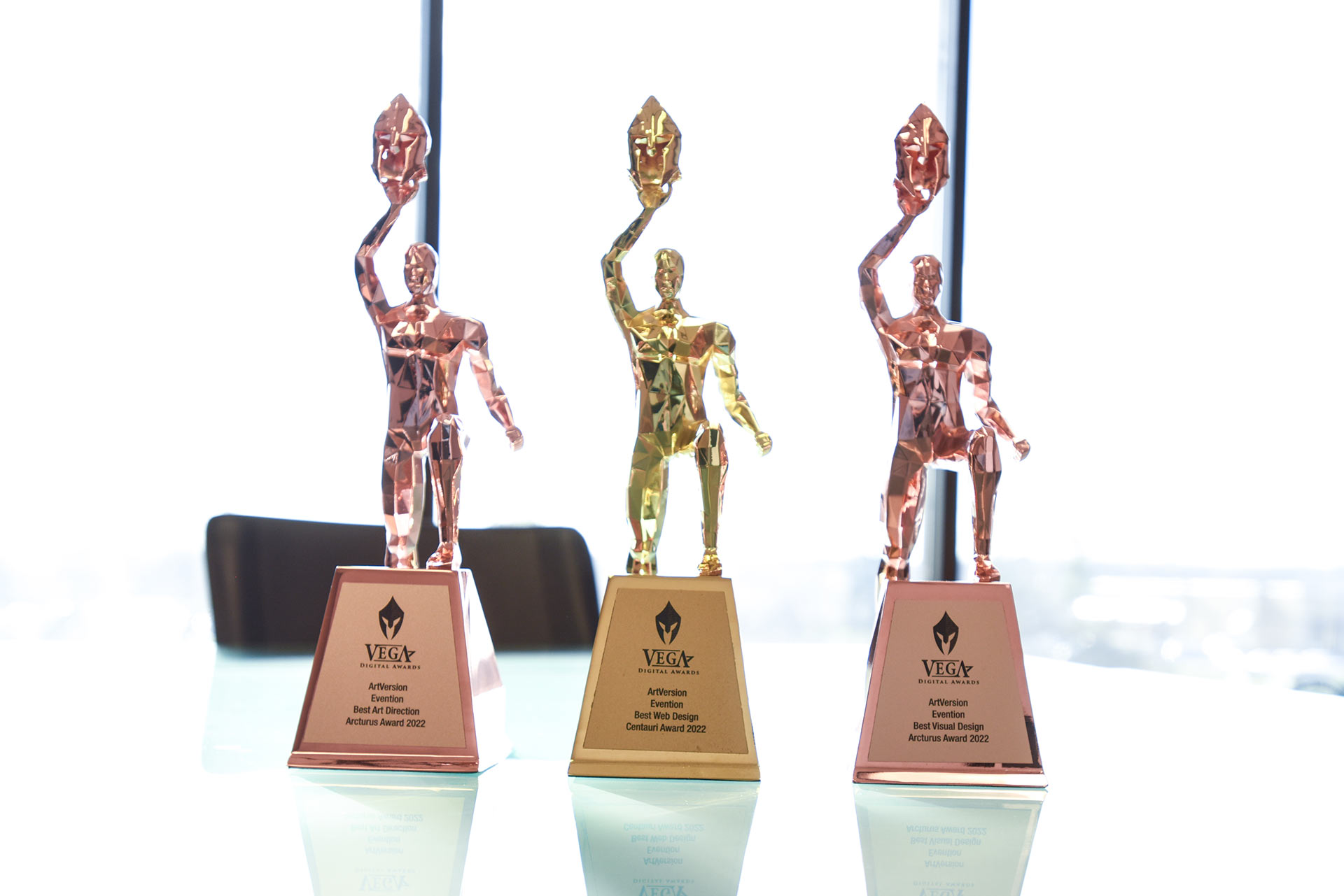 Three VEGA award trophies onto of a desk.