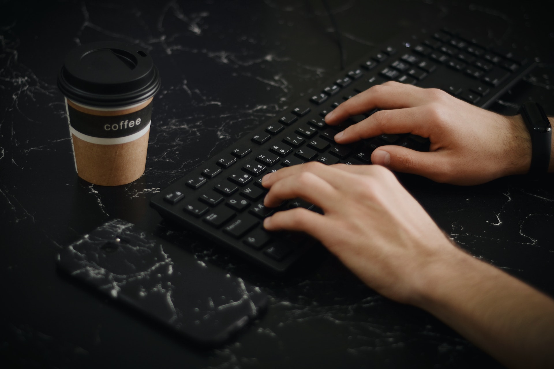 person typing on a black keyboard