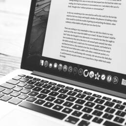 A black and white image of a laptop showcasing a Word Document.