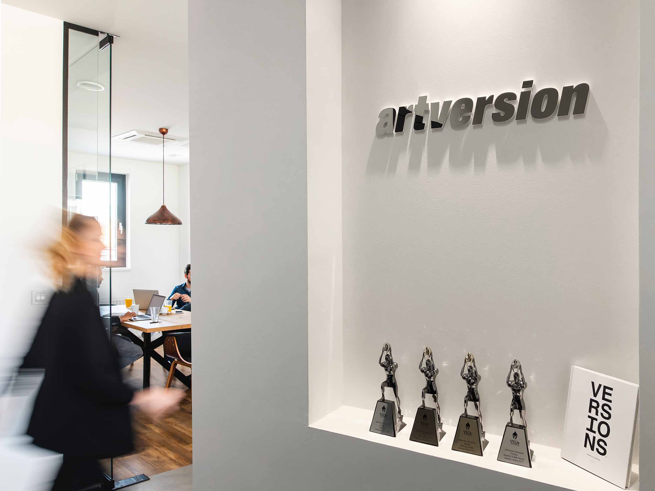 Chicago creative agency ArtVersion logo on the wall with awards beneath it.