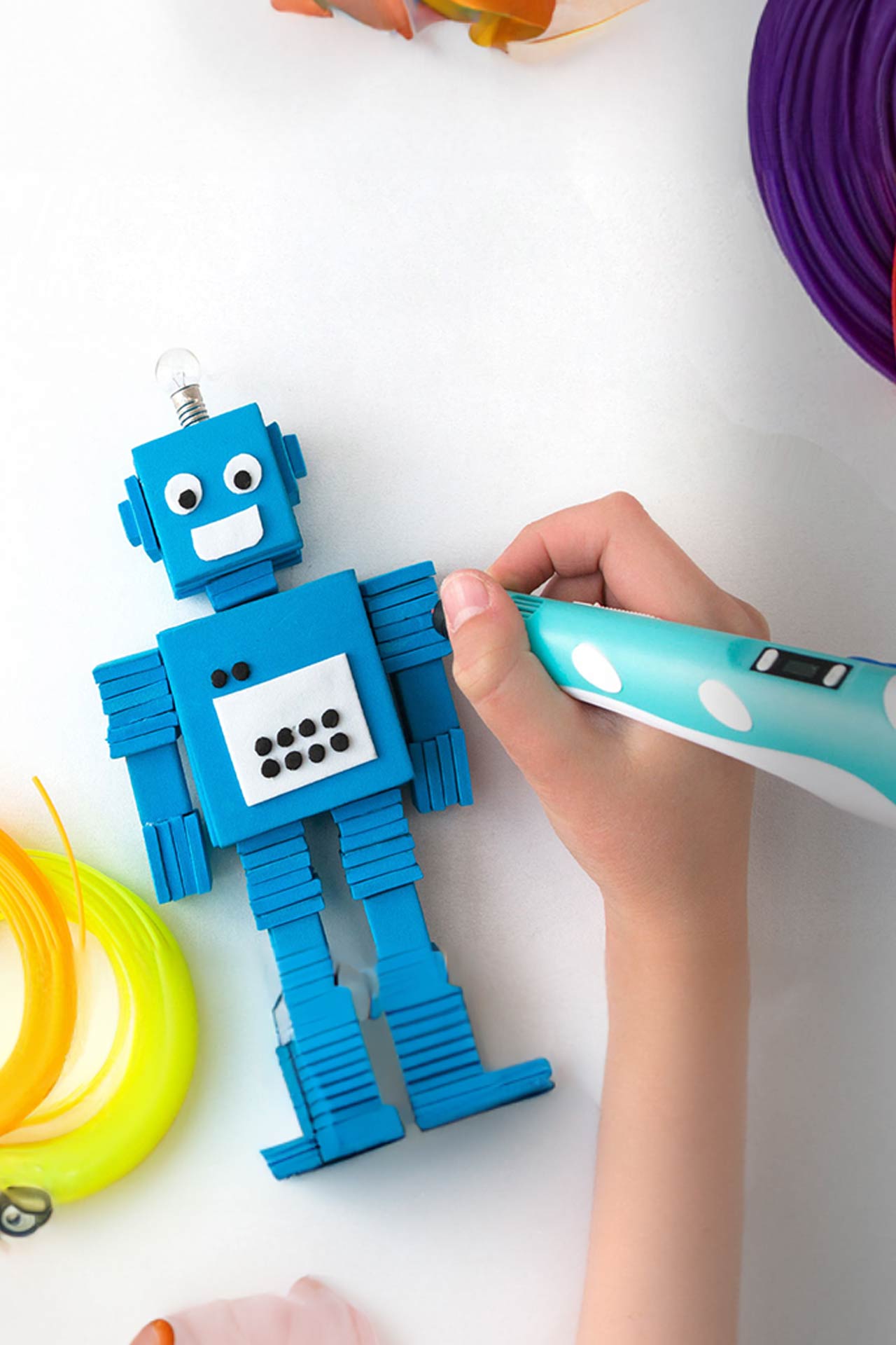 Kid creating robot with 3d pen.