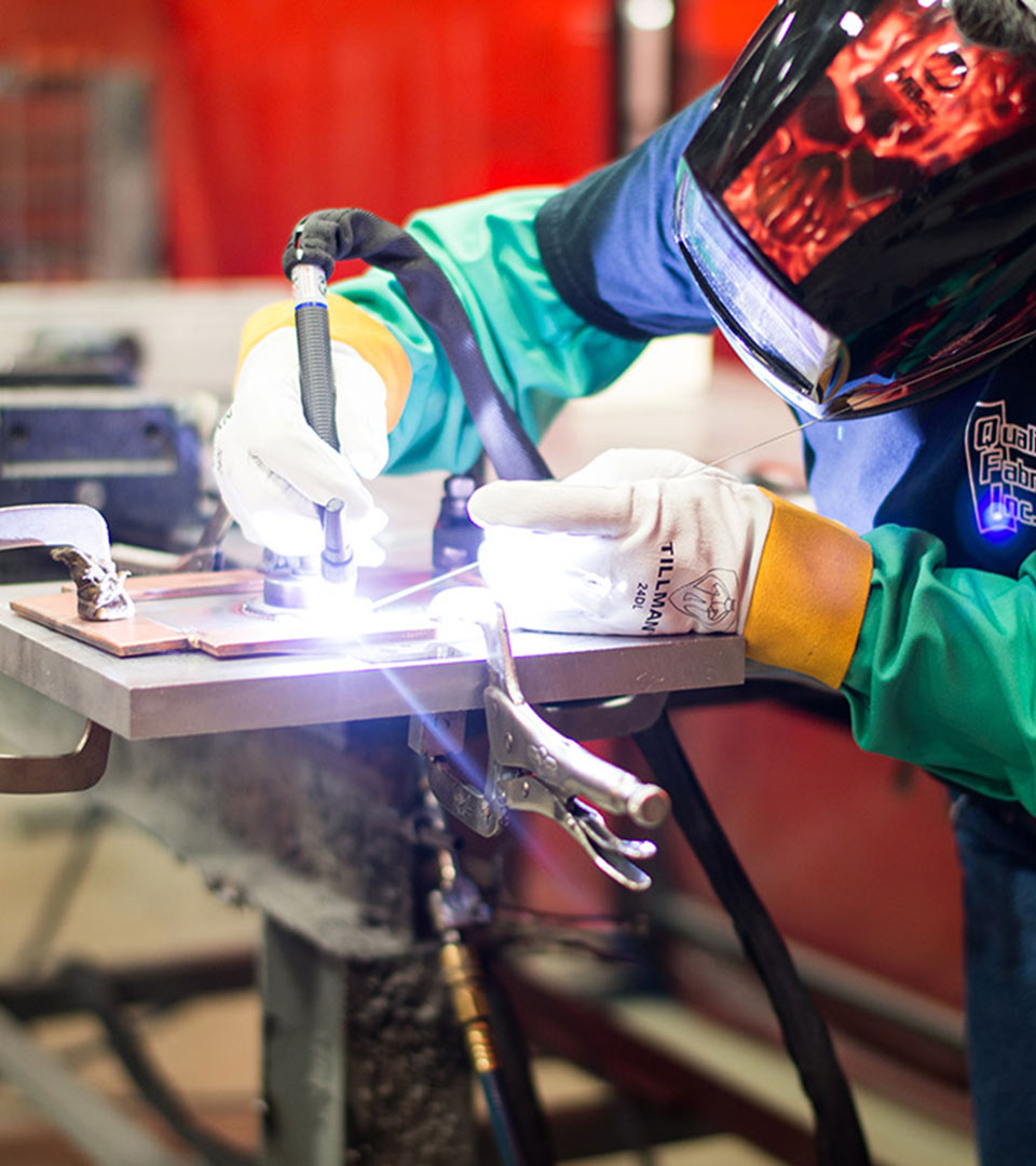 Person welding metal in the factory.