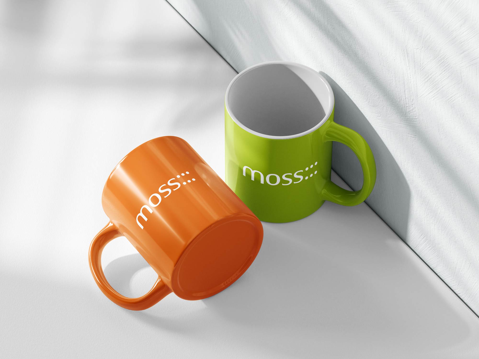 Two coffee mugs featuring an architecture firm logo.