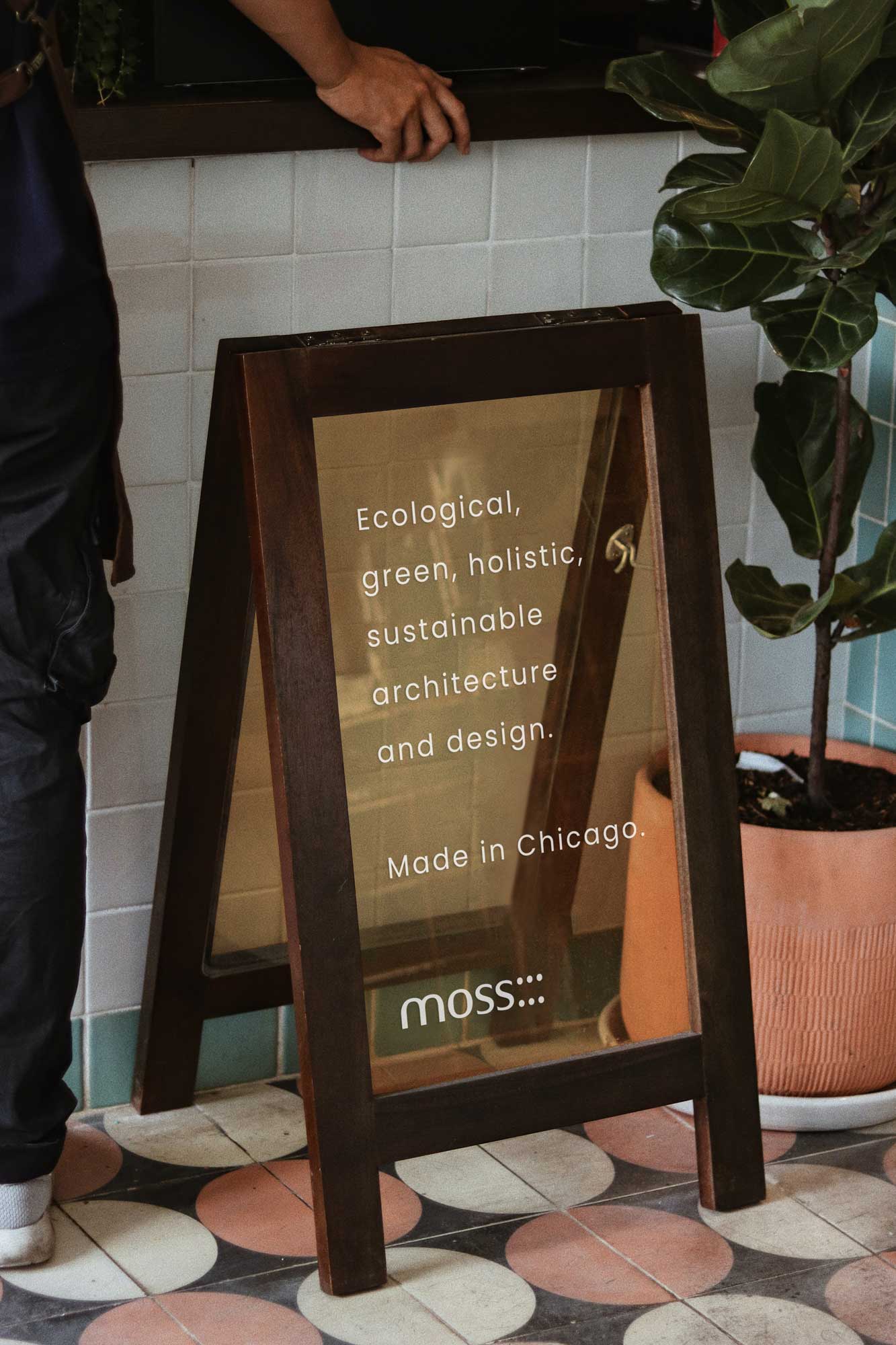 A glass stand sign advertising an architecture company.