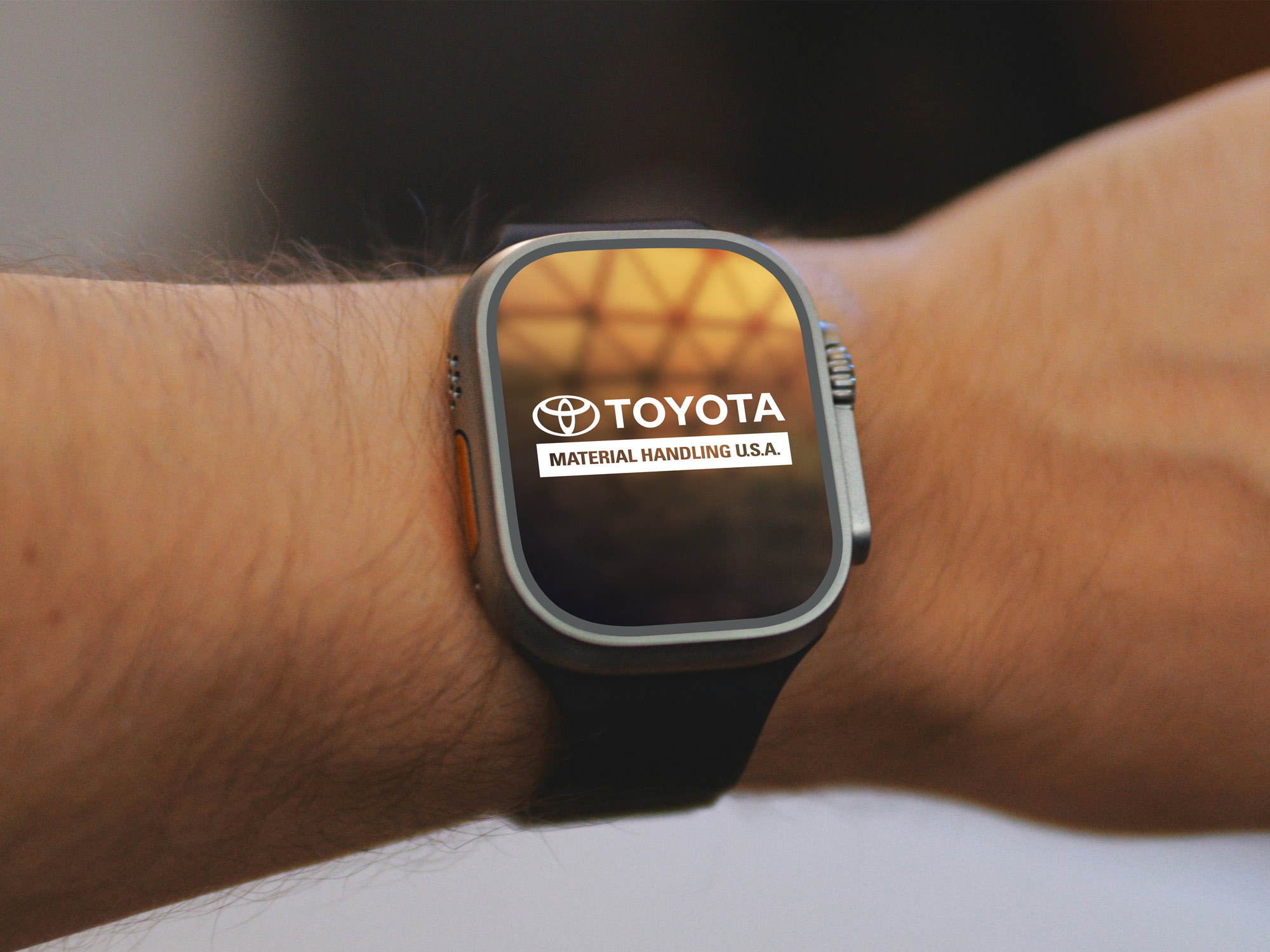 An apple watch with a screen on it advertising a manufacturing logo.