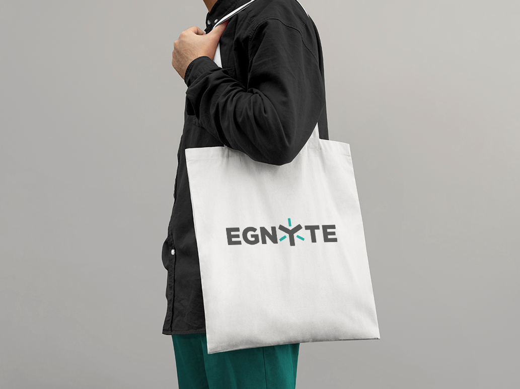 Person holding a tote bag with a tech company on it.