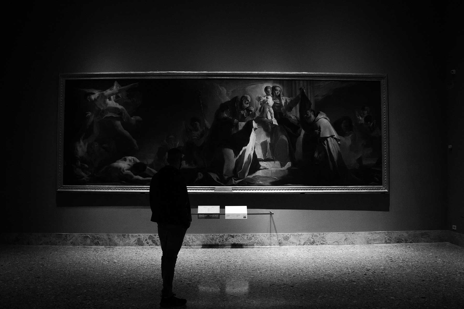 A person walkings through a gallery of fine art.