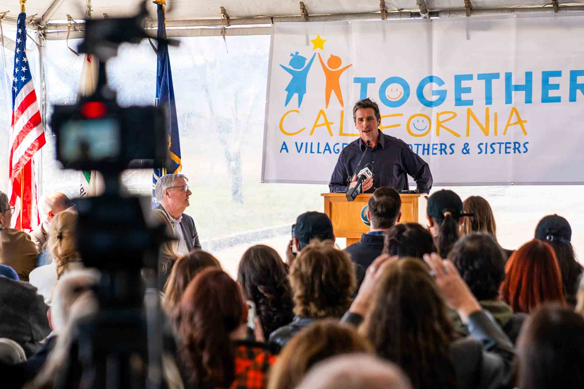 A person speaks to crowd at podium at ground breaking event.