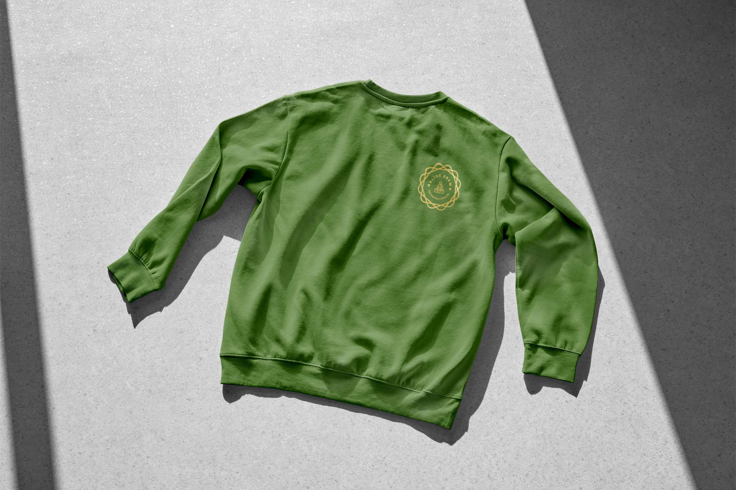 A green crewneck sweater with a yellow logo on it.