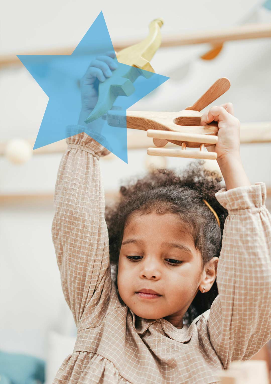Young child playing with wooden toys with a blue star overlain the top left corner.