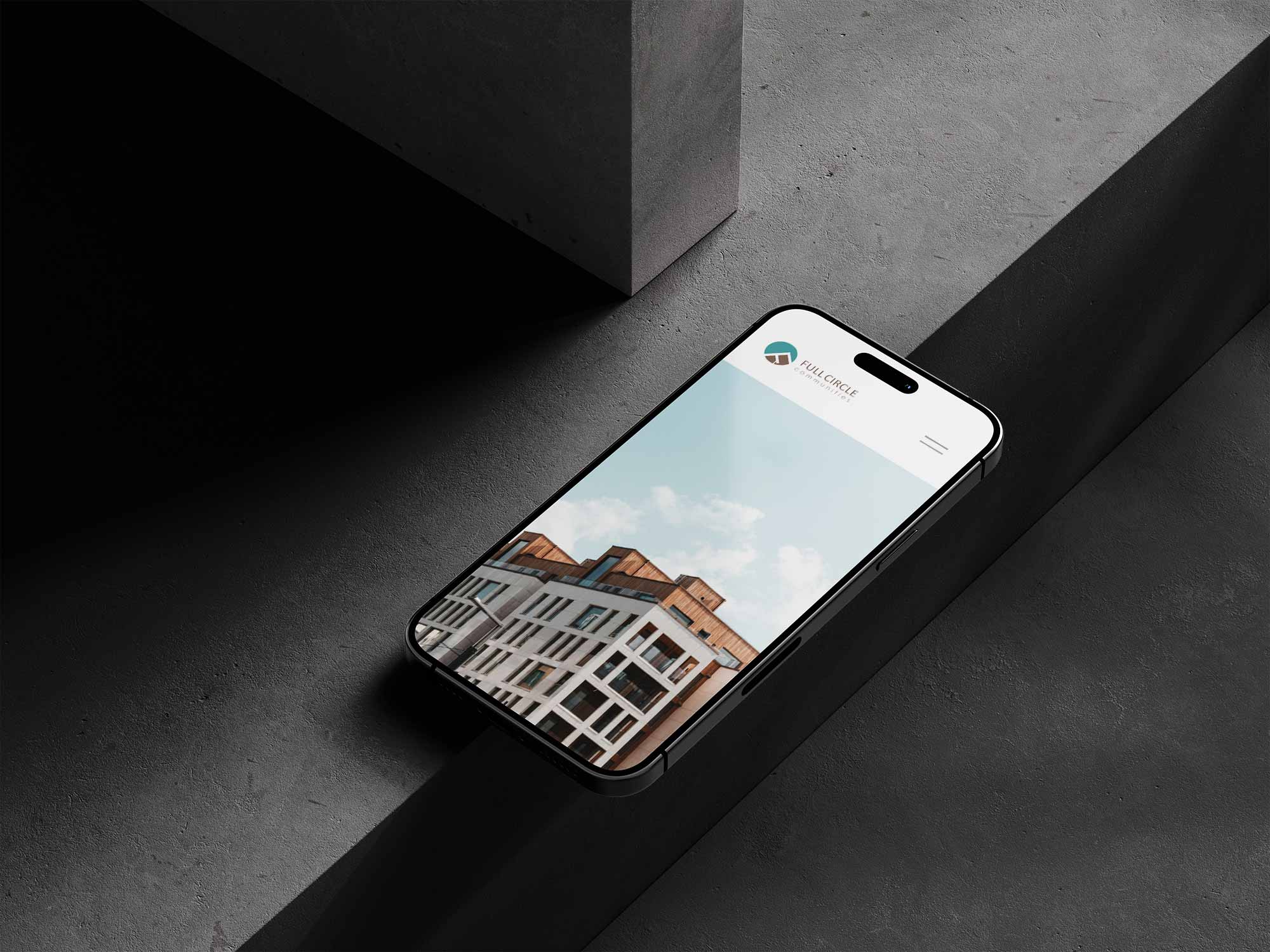 A mobile phone laying on concrete displaying an image of a building.