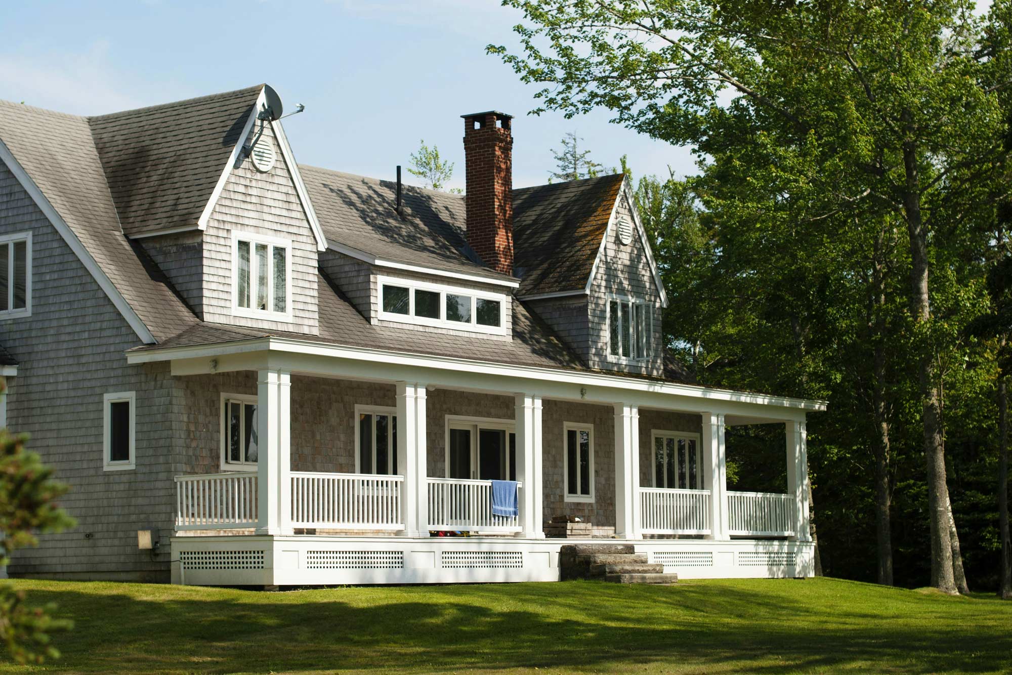 An east-coast style of home with a wrap-around white front porch.