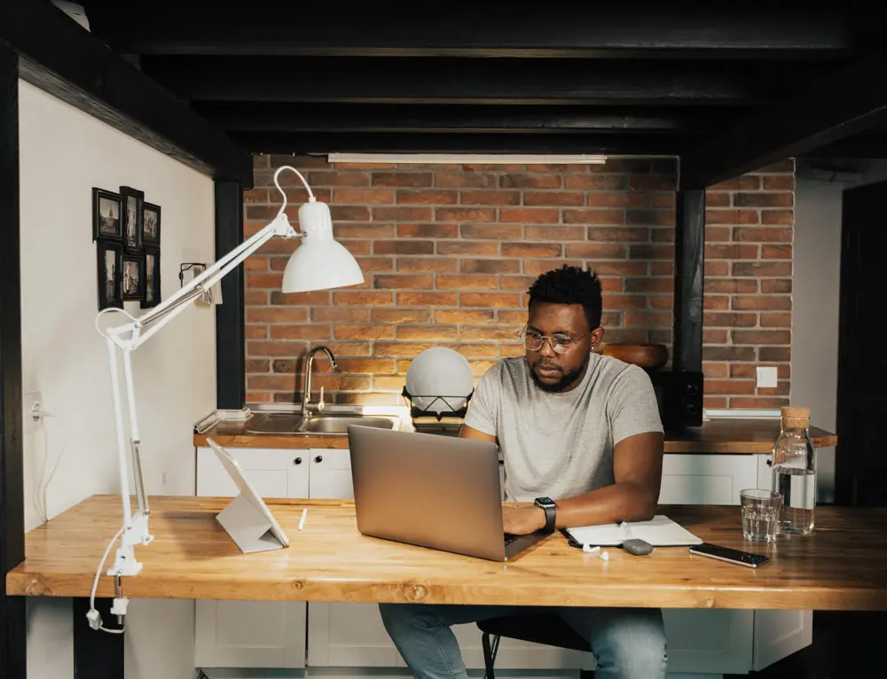 A UX designers works in studio on a laptop.