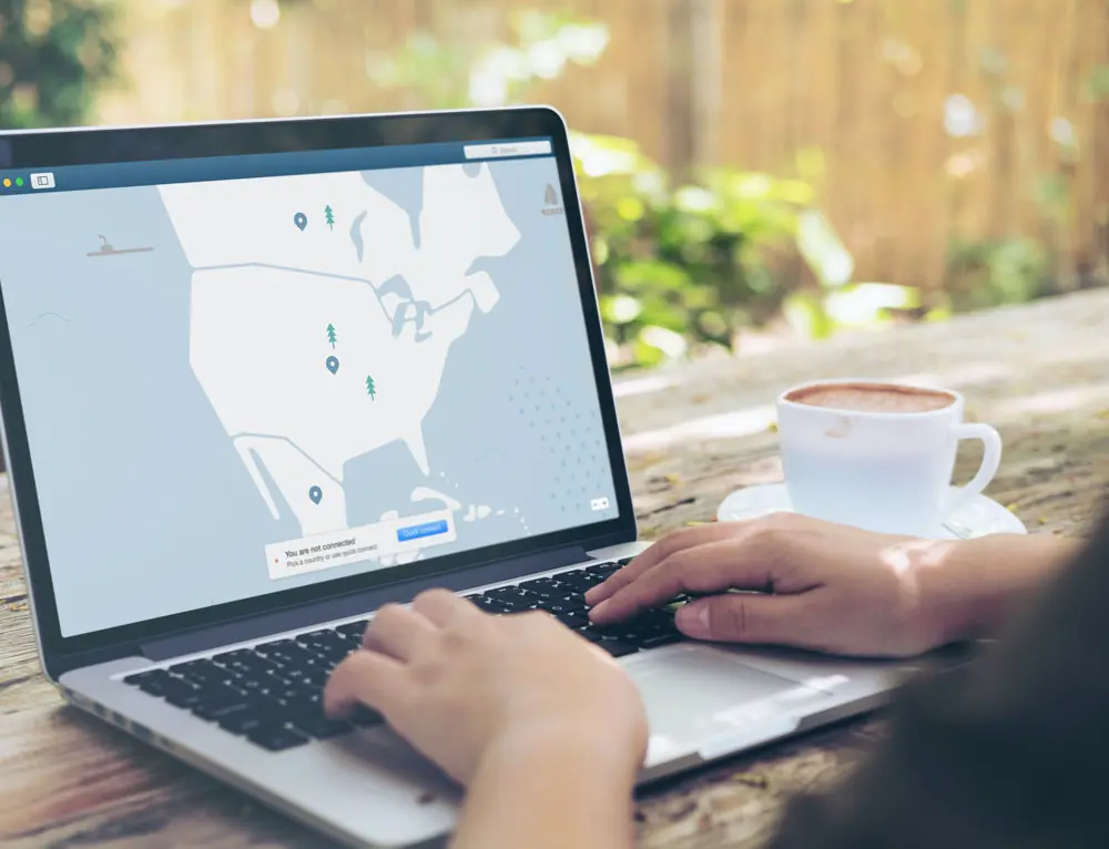 A design interacts with a map UI on a laptop outdoors.