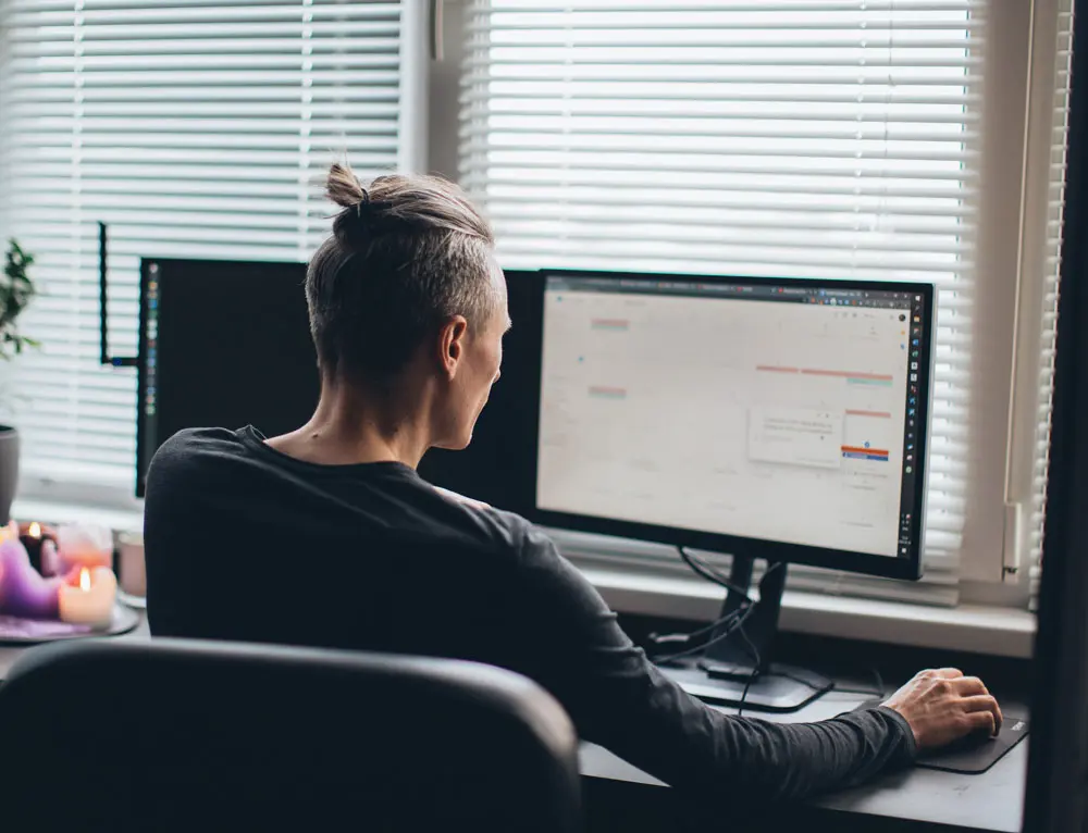 A web designer works in front of desktop display.