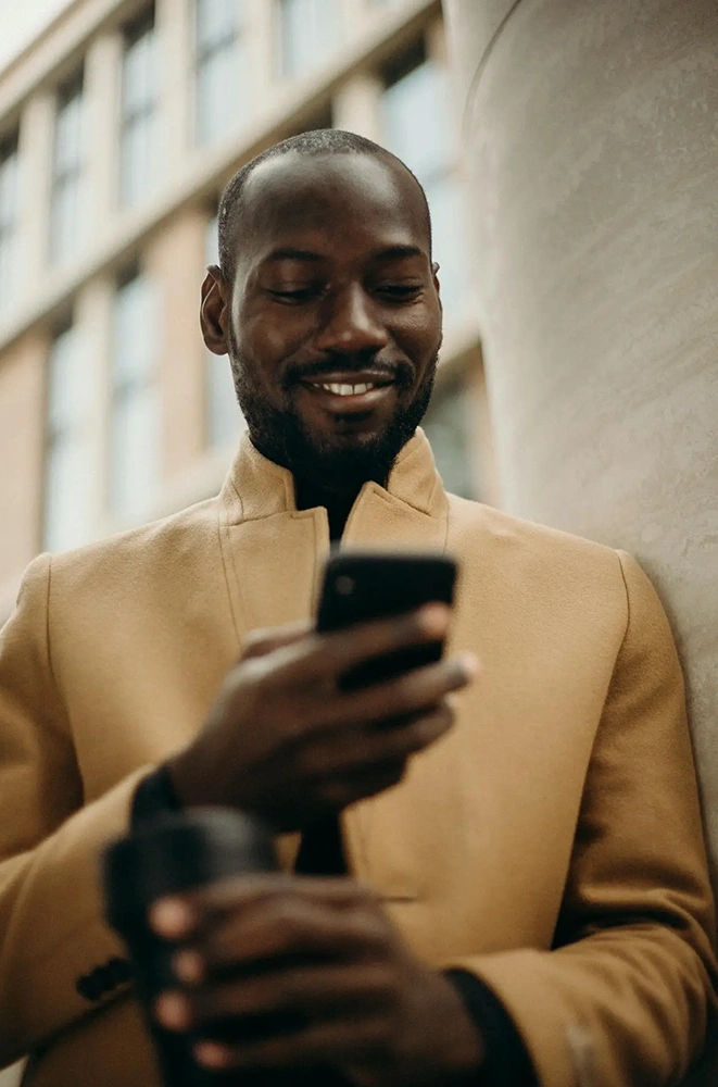 A person smiling while viewing their mobile device.