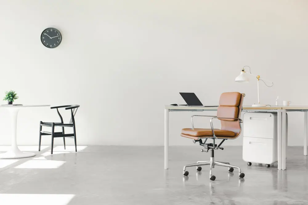 An empty studio with desks and chairs.