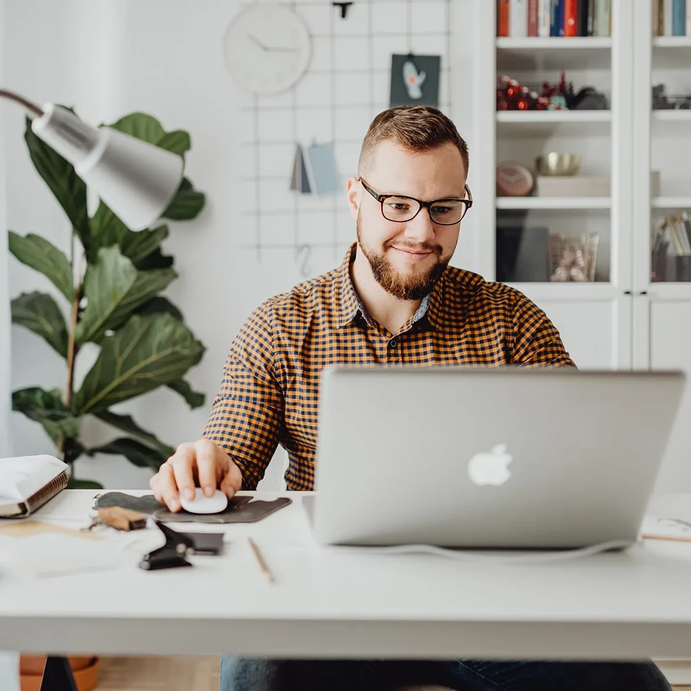 A designer working on their laptop at home.