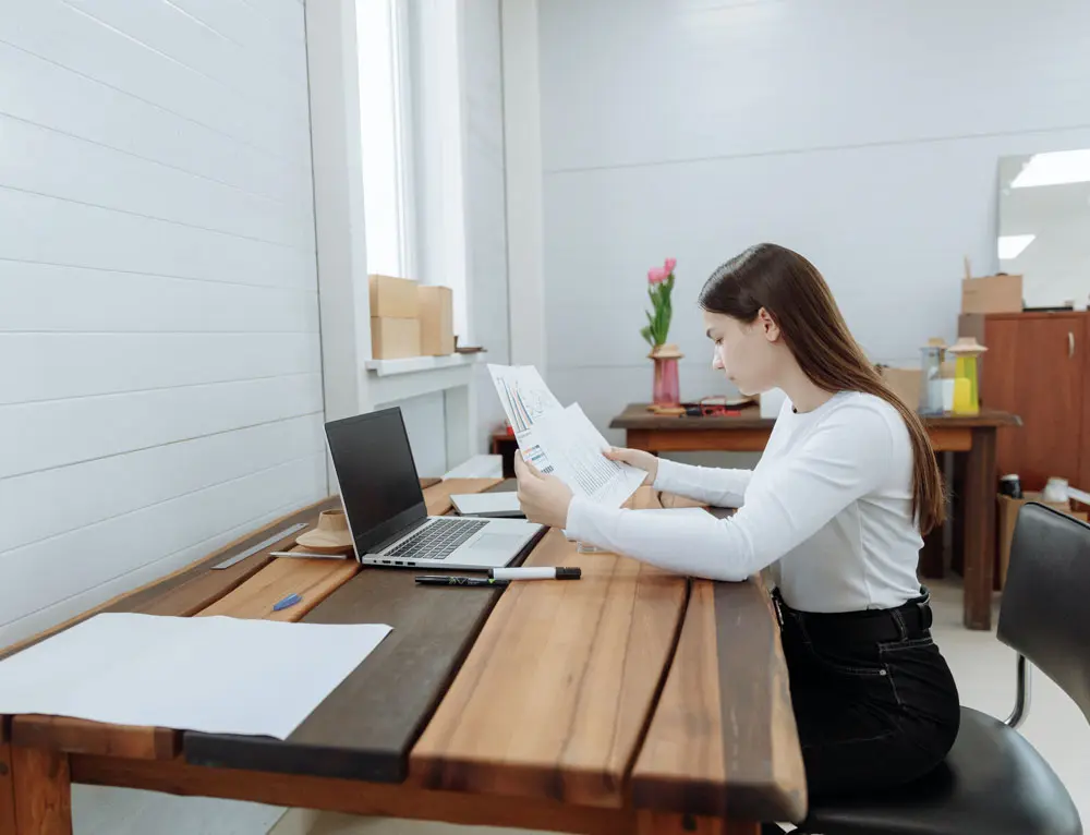 A graphic designer ideates at table with laptop.