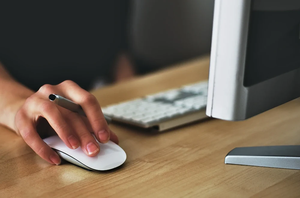 A person uses a mouse to navigate a website.