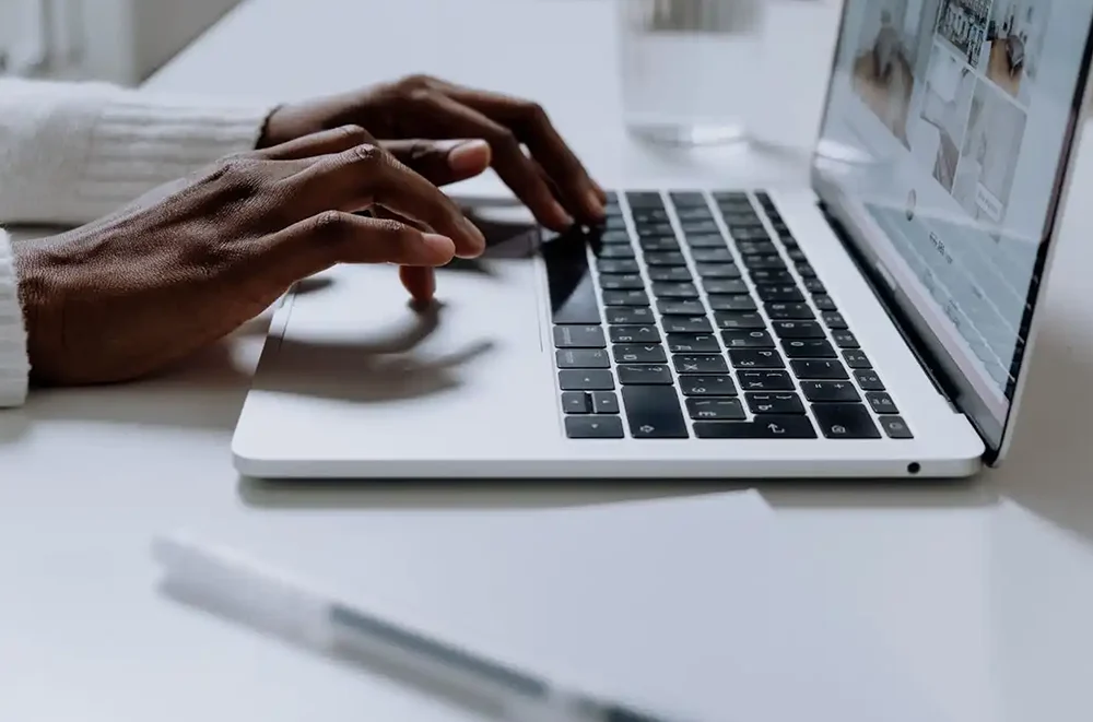 A person typing on keyboard laptop.