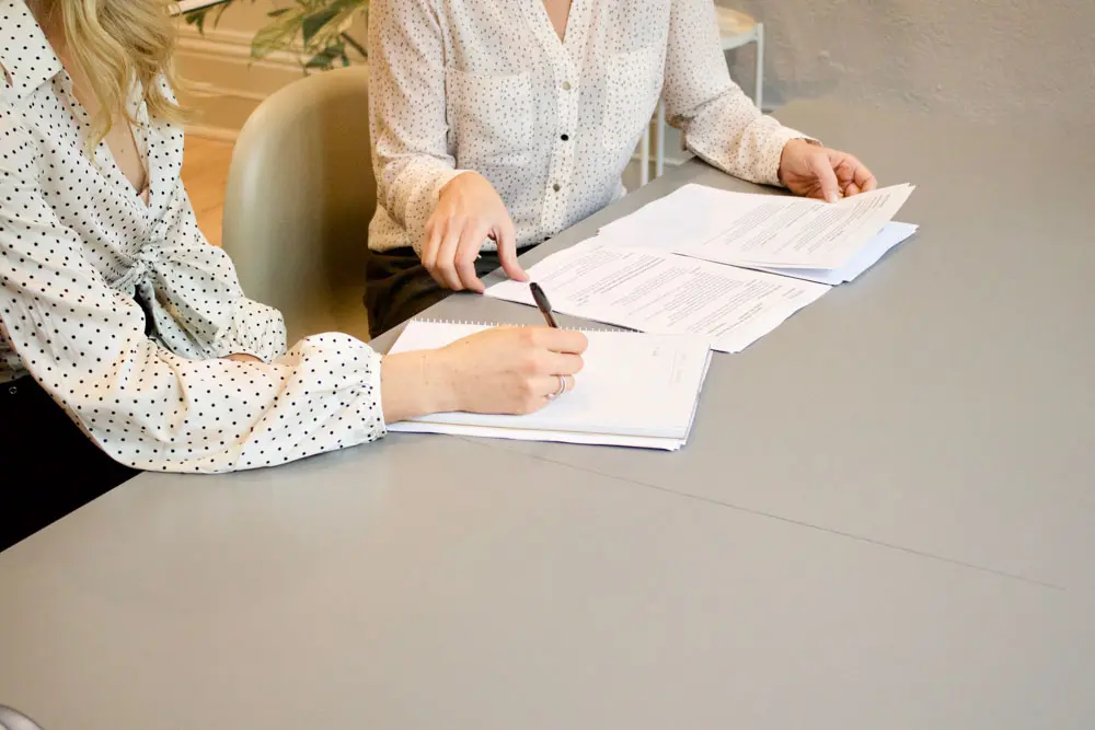 Two designers collaborate at a desk.